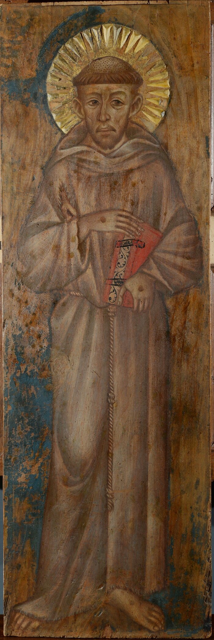 Early painted panel of Saint Francis in a patched grey-brown habit